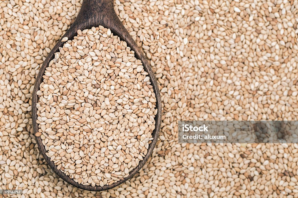 Toasted sesame seeds Wooden spoon with toasted sesame seeds Extreme Close-Up Stock Photo