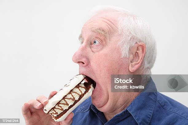 Uomo Anziano Tenta Di Mangiare Panna Fresca Eclair - Fotografie stock e altre immagini di 60-69 anni - 60-69 anni, Adulto, Alimentazione non salutare