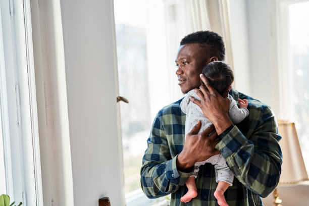 istock Caring father holding newborn standing at home 1724616296