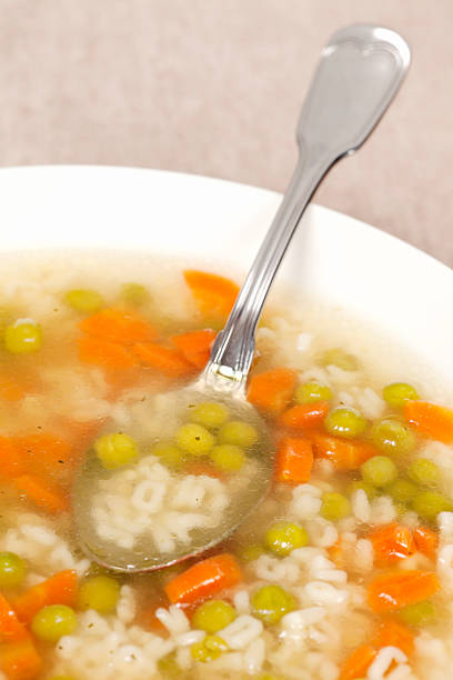 Chicken broth with vegetables Chicken broth - soup with carrots and peas, without meat. Decorated with parsley. Selective focus, shallow DOF. cooked selective focus vertical pasta stock pictures, royalty-free photos & images