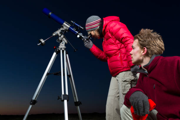 istock Two amateur astronomers with telescope at night 172462590