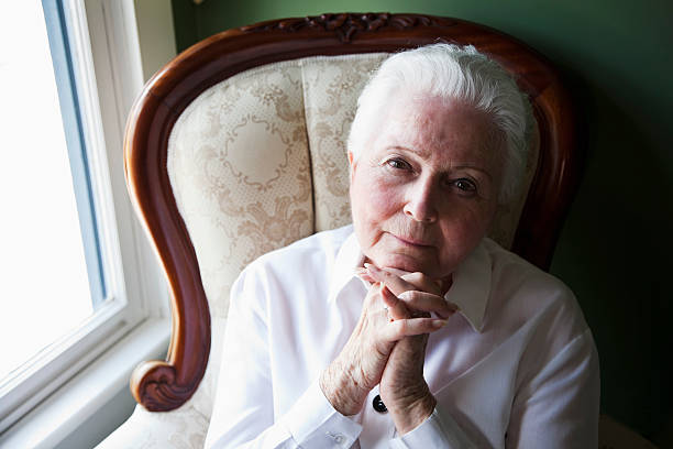 anziani donna seduta da finestra - sc0570 foto e immagini stock