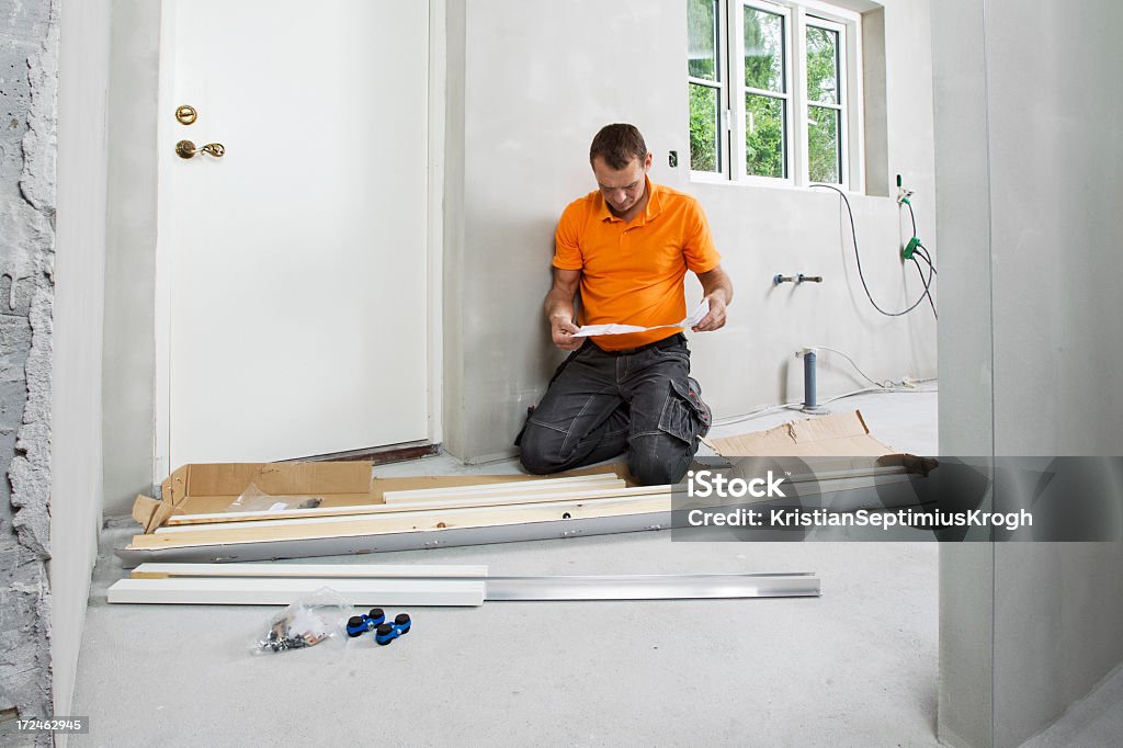 Man reading assemply plan - Foto de stock de Adulto libre de derechos