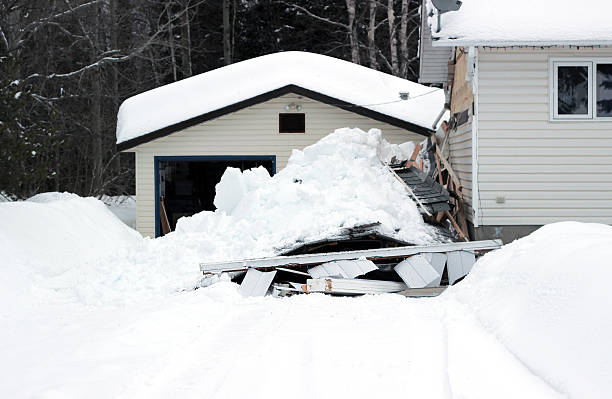 Snow that has collapsed a roof A photograph of a snow covered carport that has collapsed on top of two vehicles. collapsing stock pictures, royalty-free photos & images