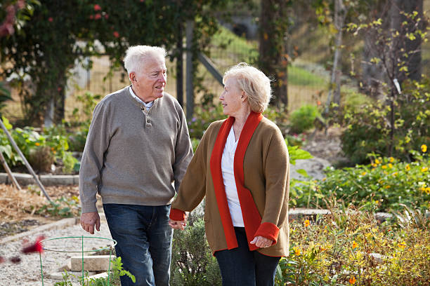 istock Senior couple holding hands, walking through garden 172464059