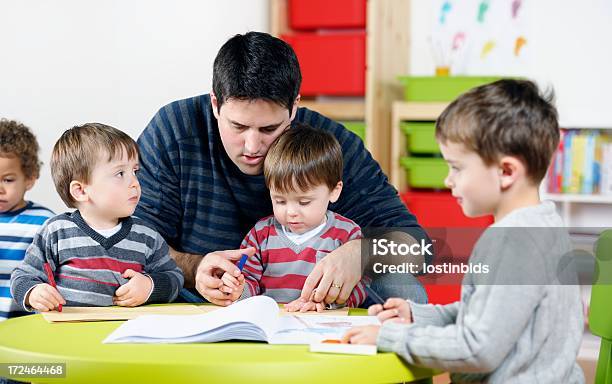 Group Of Toddlers And Little Boy Being Supervised During Artwork Stock Photo - Download Image Now