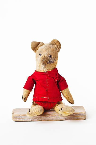 Scene with vintage teddy bear in red suit. Vintage teddy bear with red shirt sitting on a piece of wood.. winnie the pooh photos stock pictures, royalty-free photos & images