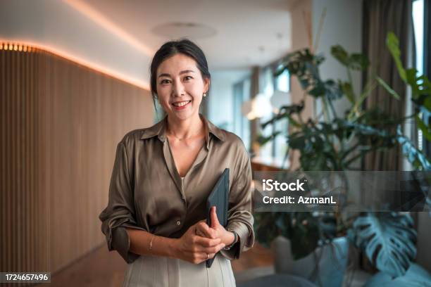 Smiling Female Korean Corporate Employee With Digital Device Stock Photo - Download Image Now