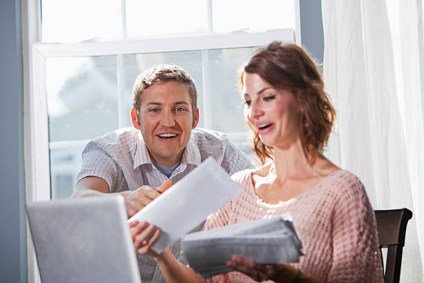 Home finances Happy couple at home paying bills.  Focus on man (20s). Sc0601 stock pictures, royalty-free photos & images