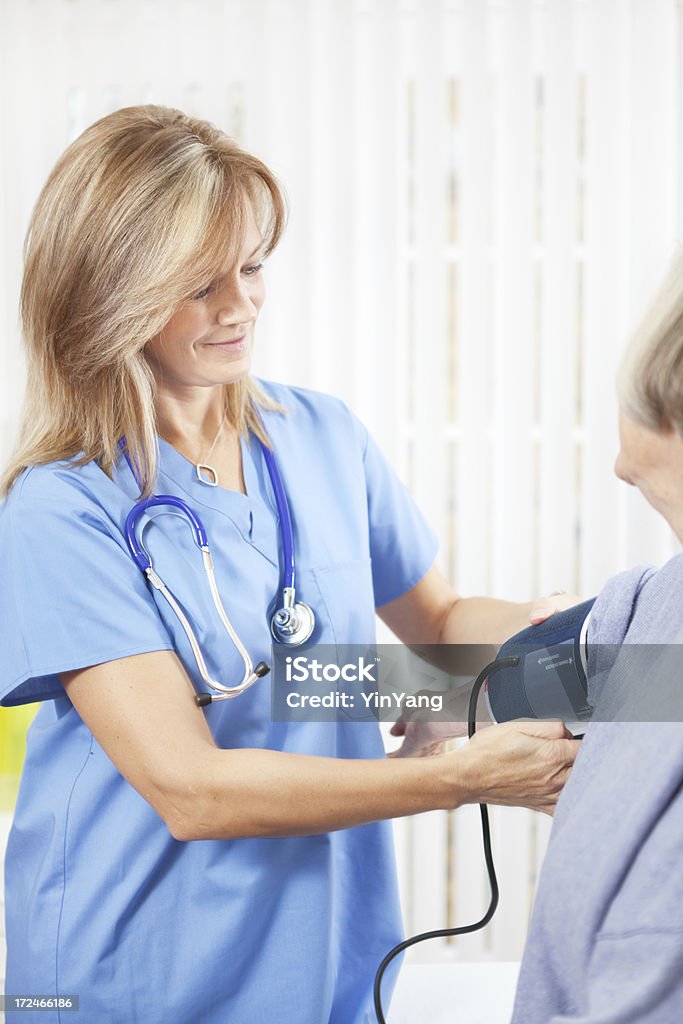 Senior con enfermera de comprobación de la presión arterial del dispositivo de Vermont médico - Foto de stock de Clínica médica libre de derechos