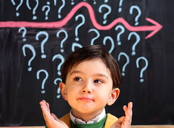 Photo of Child contemplating question marks