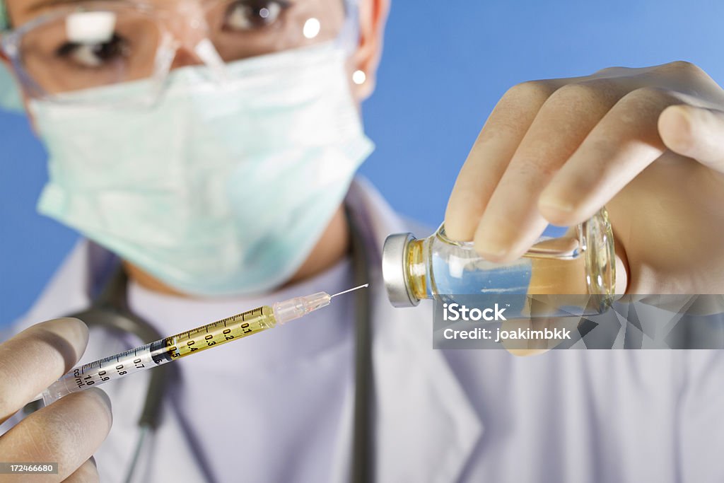 Nurse preparing a syringe A medical worker is preparing an injection; selective focu on the syringe.Similar choices below: Adult Stock Photo