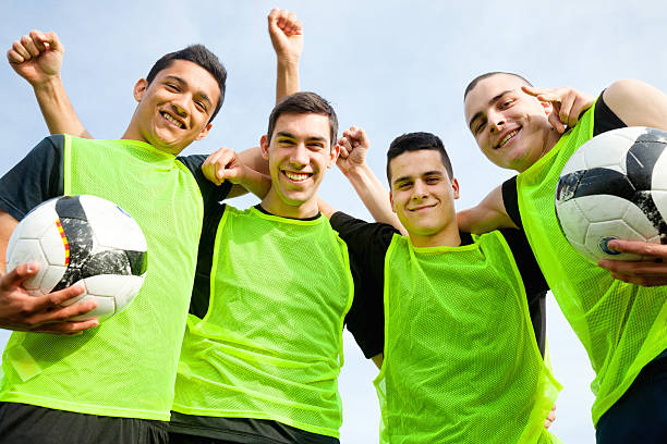 istock Smiling soccer team makes victorious hand gestures 172466924