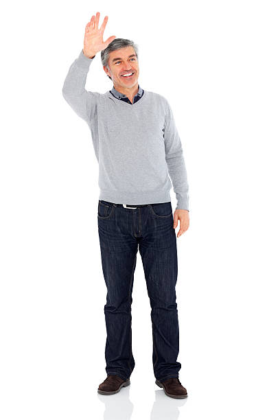 Smiling mature man waving hand on white