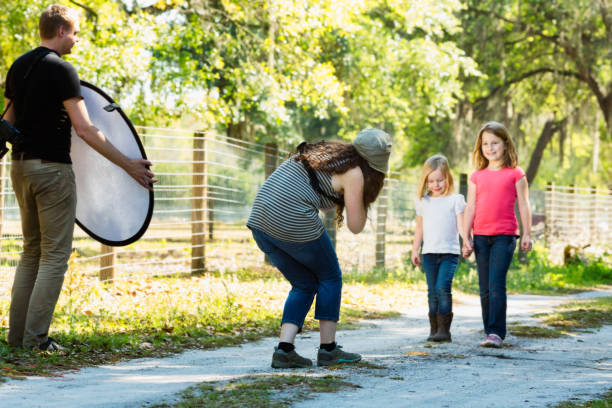 Children photographer at work with assistant holding reflector