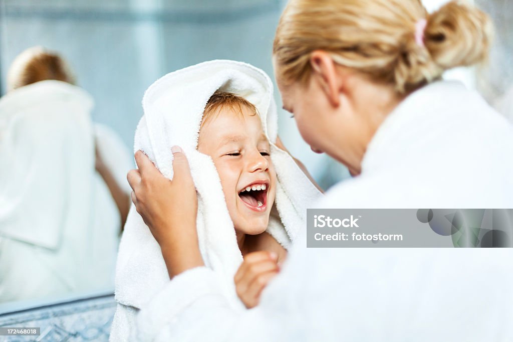 Mother drying up son after bath Mother drying up child's hair with a towel in a bathroom after bath. Child Stock Photo