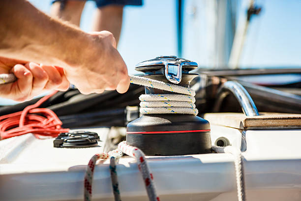 segeln crew-mitglieder ziehen seil auf segelboot - cable winch sailing yacht sport stock-fotos und bilder