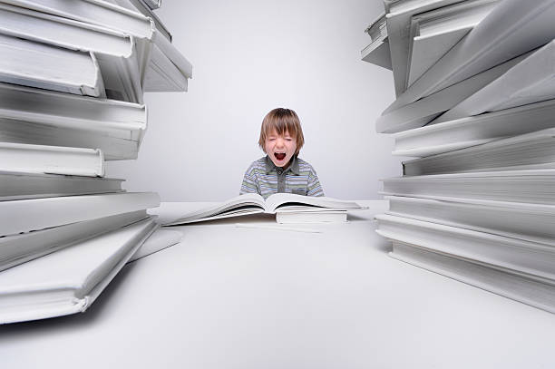 istock Young boy screaming with frustration over his homework 172468535