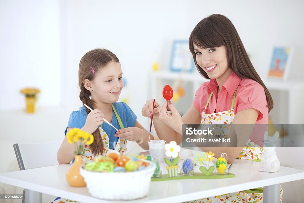 Easter fun. Happy smiling mother with daughter coloring eggs for easter. Looking at camera.See more EASTER images with this MOTHER and DAUGHTER. Click on image below for lightbox. 30-39 Years Stock Photo