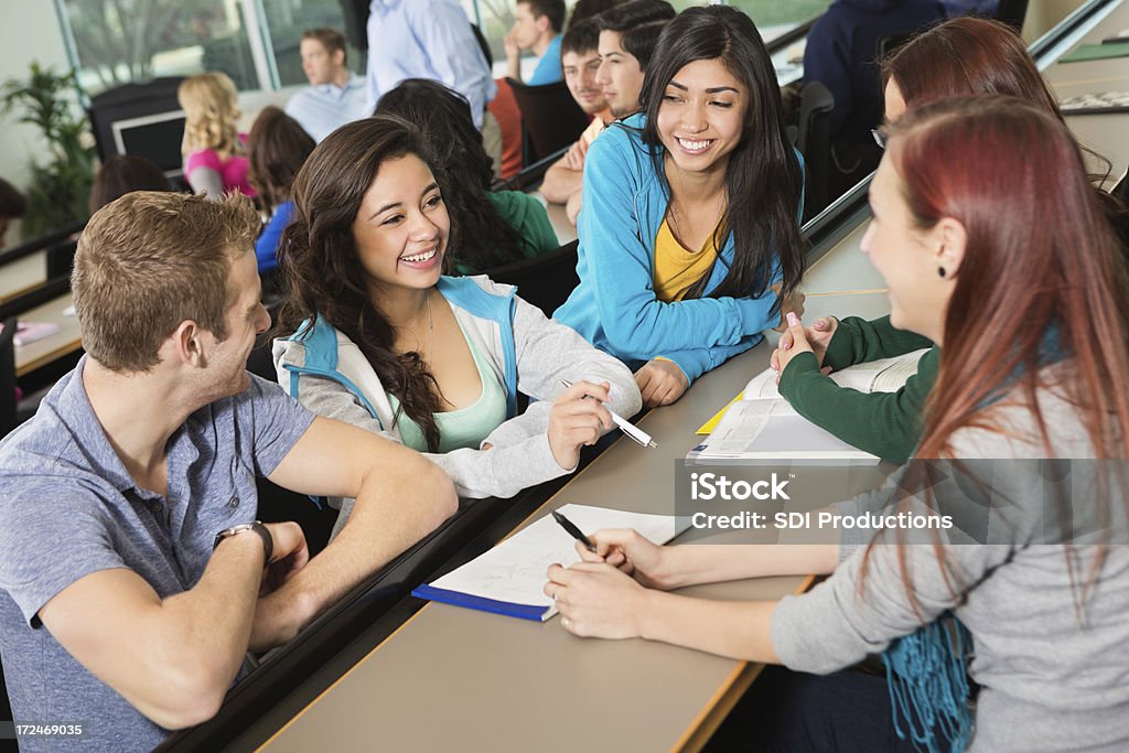 Grupo diverso de estudiantes trabajando en clase proyecto común - Foto de stock de Escuela secundaria libre de derechos