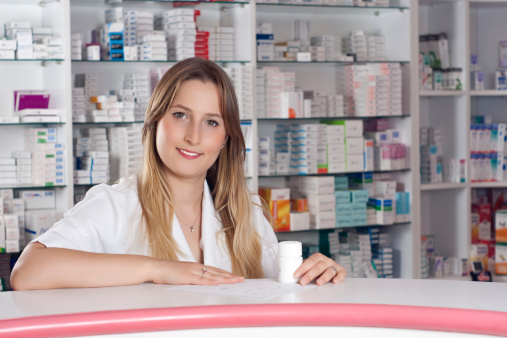 Smiling woman pharmacist showing assortment of care products in pharmacy