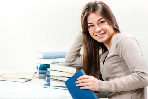 Portrait of Cute Young woman with many books. Looking at camera.