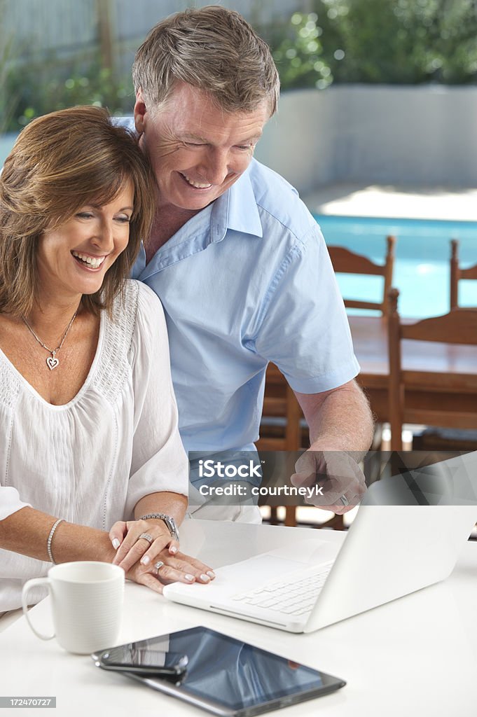 Pareja madura feliz usando tecnología inalámbrica - Foto de stock de 40-44 años libre de derechos