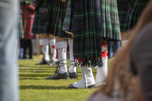 Scottish festival with the feet of a parade of bagpipers playing with a larger band - Scotch Pipers.
