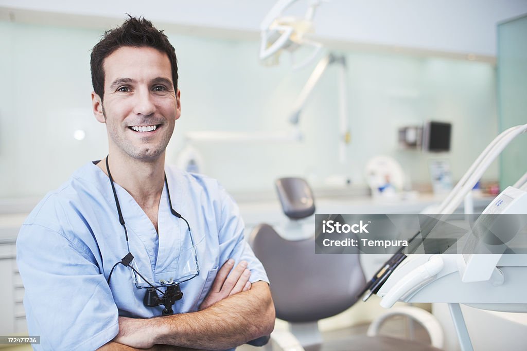 Dentista sonriente en la sala de examen - Foto de stock de Dentista libre de derechos