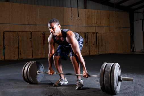 Weight lifter - Young black man (20s) preparing to lift barbell.