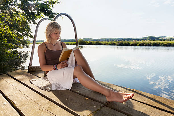 istock young woman reading book outdoors in summer 172472167