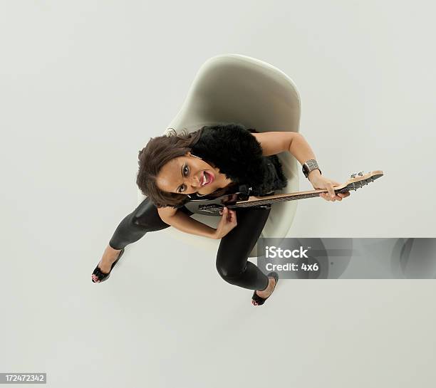 Foto de Vista De Alto Ângulo De Uma Mulher Tocando Guitarra Em Cadeira e mais fotos de stock de Cantor