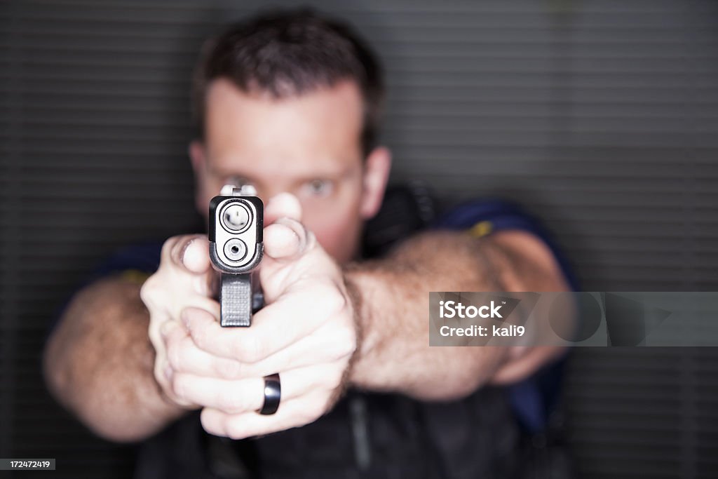 Oficial de policía con un arma - Foto de stock de 20 a 29 años libre de derechos