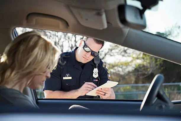 Police officer giving woman a traffic ticket.  (20s).