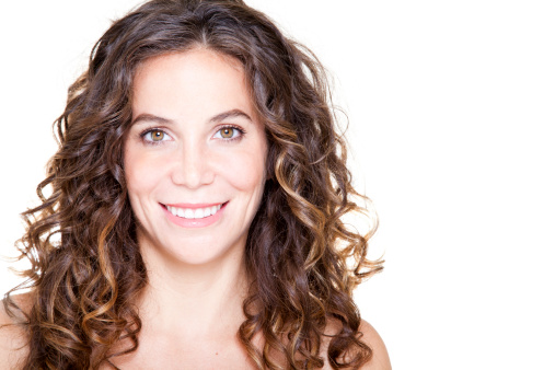 Young woman with clear skin and curly hair. Brightly lit.