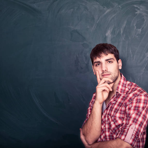 istock Young man standing in front of a blackboard 172473021