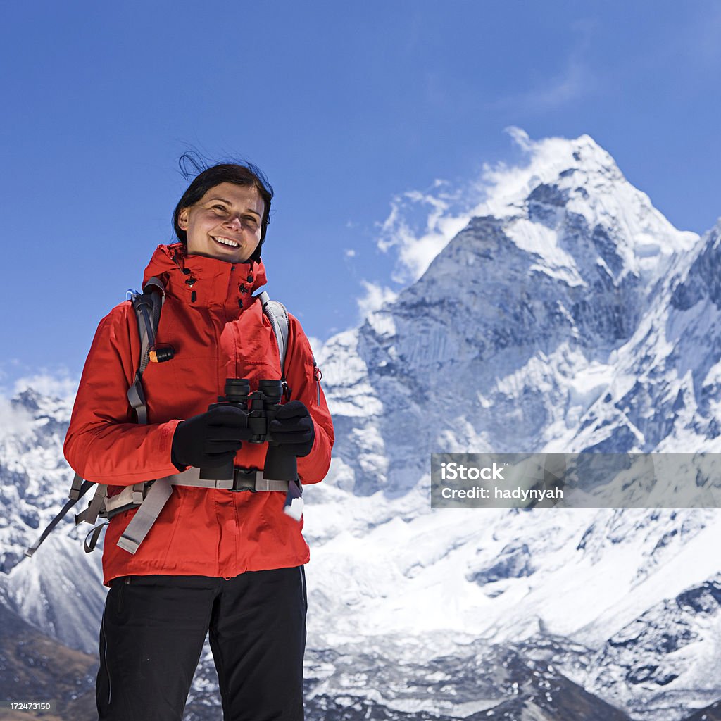 Mujer está mirando a través de binoculares en parque nacional de monte Everest - Foto de stock de 20-24 años libre de derechos