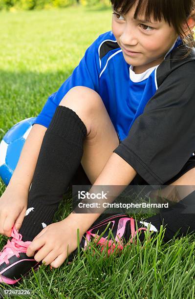 Jovem Menina Amarrar Os Sapatos De Futebol - Fotografias de stock e mais imagens de Raparigas - Raparigas, 8-9 Anos, Alegria