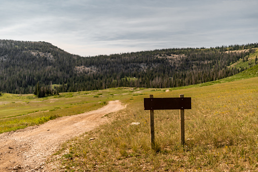 Wooden sign on the top of Mt.Washburn in Yellowstone National Park, Wyoming, USA with vast mountain landscape in the back. Nice day hiking in the mountains