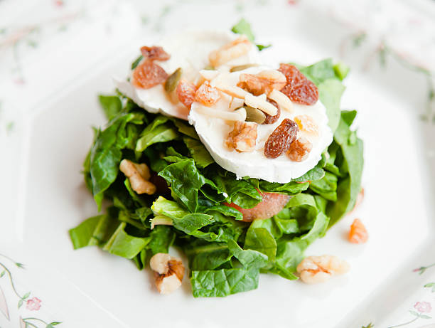 Spinachs and goat cheese salad with dried fruits stock photo