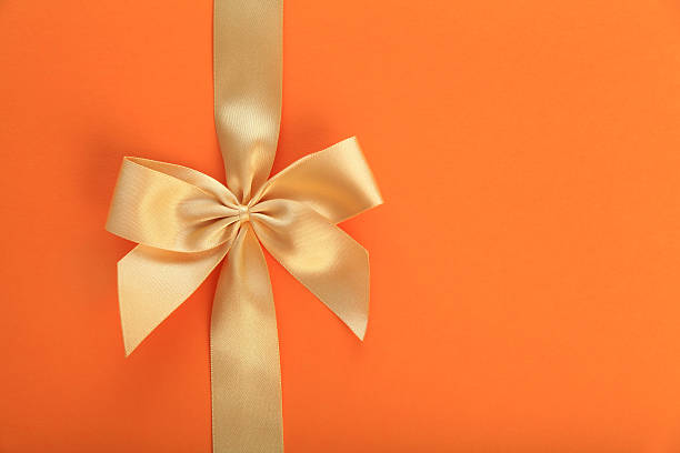 istock Golden bow on orange background 172473819