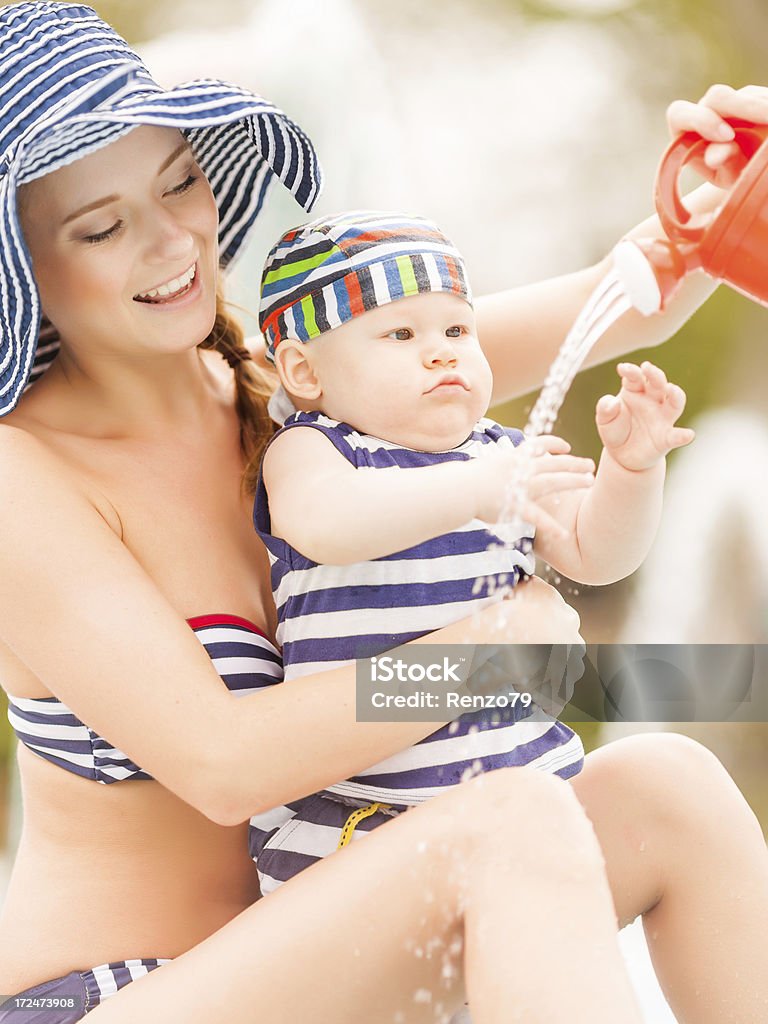 Niño feliz con mamá en swimingpool - Foto de stock de 20 a 29 años libre de derechos