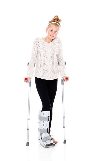 istock Pretty young girl on crutches over white 172475312