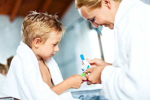 istock Mother and son brushing teeth together 172476516