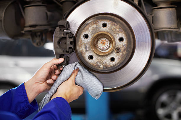 Break pad and plate must be in good shape! A mechanic cleaning a cars wheel bearing with a cloth car mechanic top view stock pictures, royalty-free photos & images