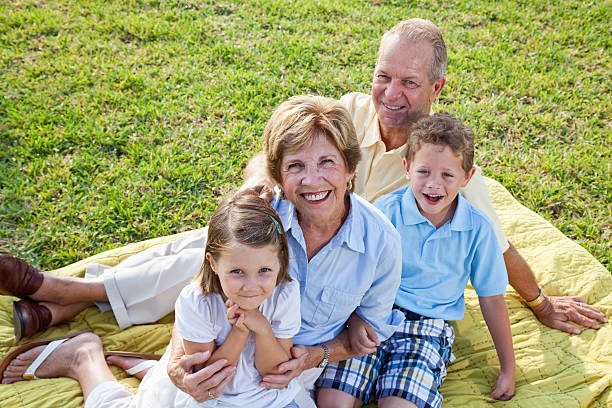 Portrait of grandparents and grandchildren Portrait of grandparents sitting on picnic blanket with grandchildren (4 and 6 years). Sc0560 stock pictures, royalty-free photos & images