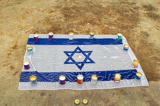 Mourning candles burning on Israel national flag background.Holocaust memory day. Moment of silence concept. Close up, copy space.