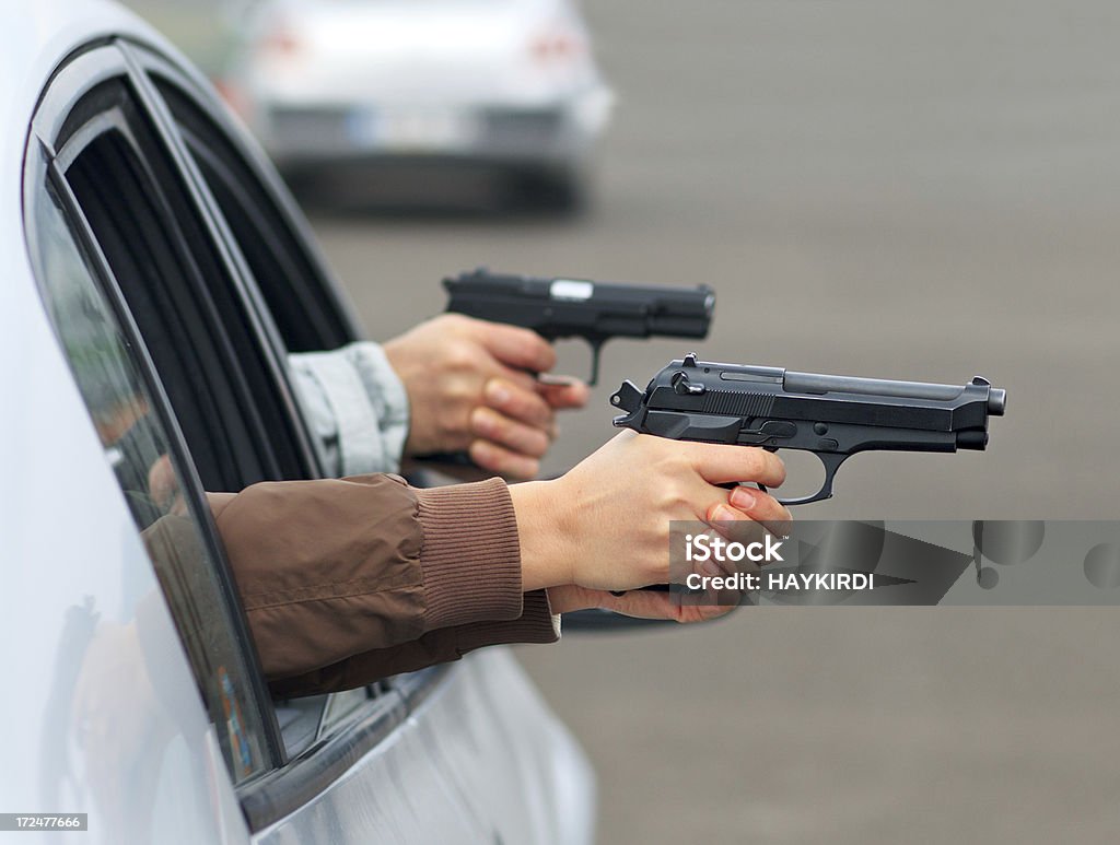 Tiro con dos manos en el coche con pistola - Foto de stock de Adulto libre de derechos