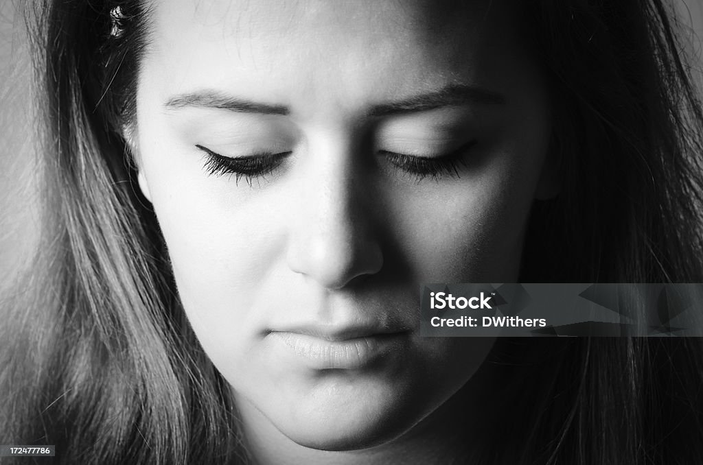 Sad Young Woman Looking Down Black and White Portrait Black and white photo of a sad young woman looking down.Click a thumbnail for other views of the same model. 20-29 Years Stock Photo