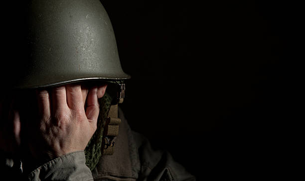 Soldier in his helmet with hands covering face stock photo